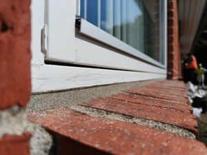 Et vindue som har sandbestrøget fuger så de matcher mørtelfugerne i murværket